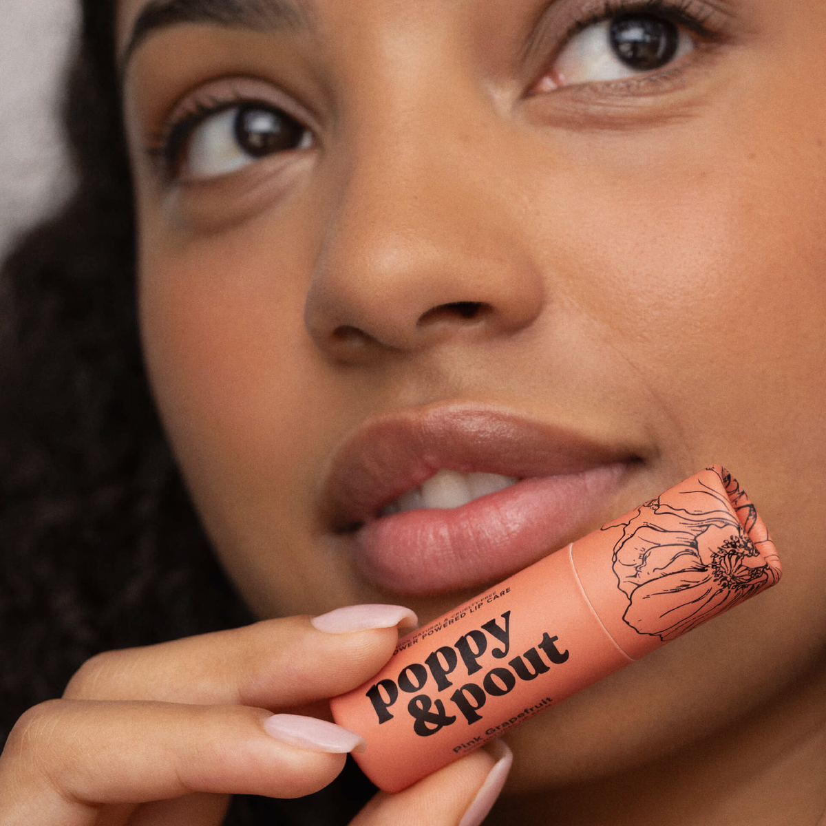 Poppy and Pout Pink Grapefruit lip balm - model applying